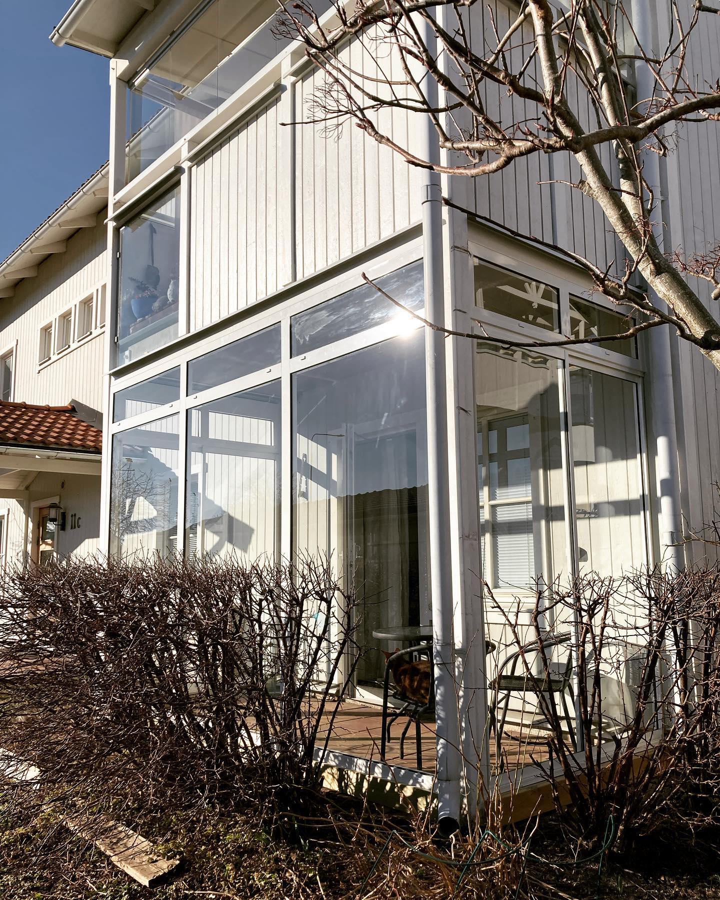 Inglasad balkong Inglasad balkong i vårsol på vitt radhus.